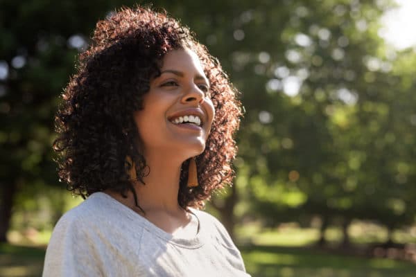 Smiling young woman enjoying a sunny day in the park