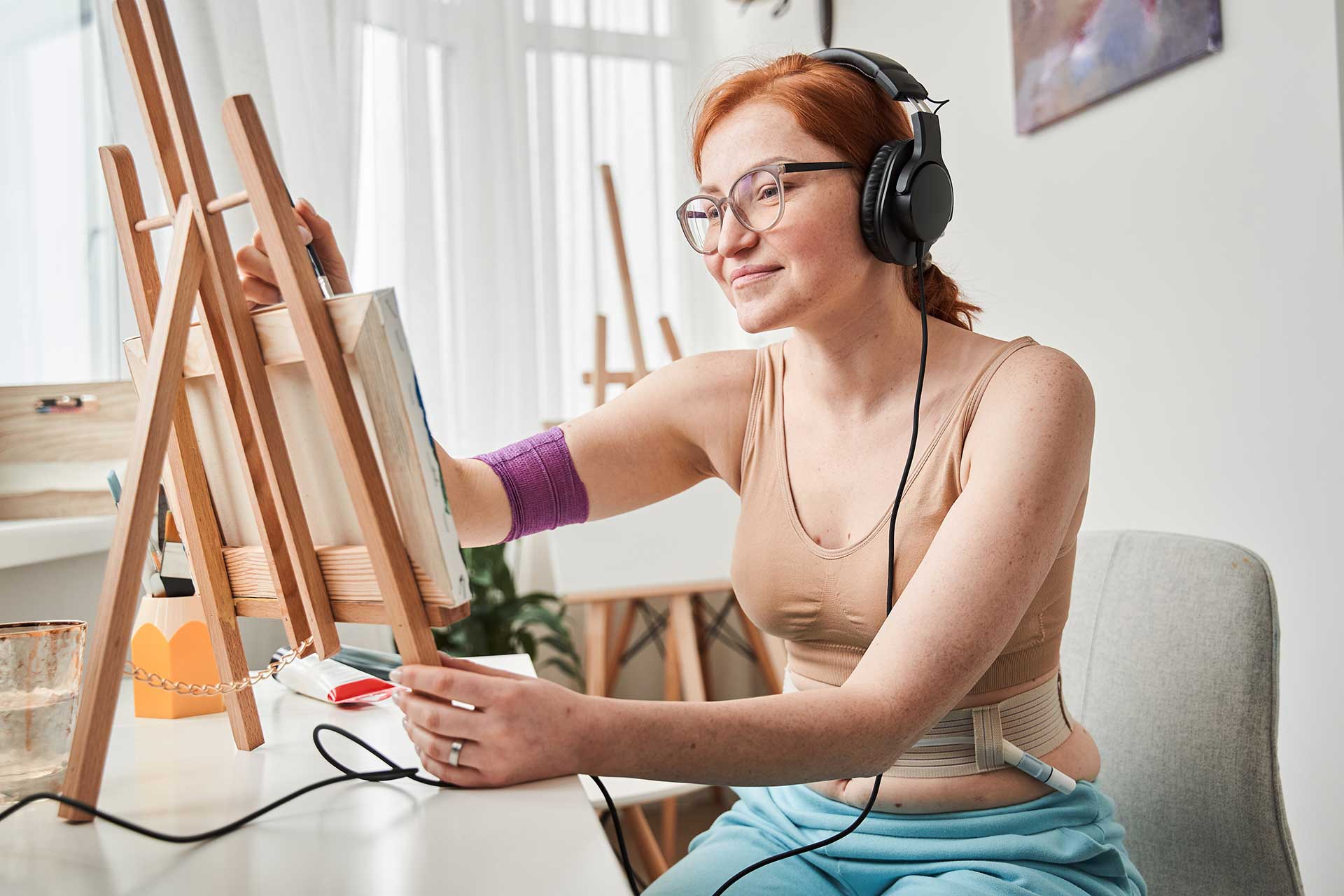 A young woman with headphones painting